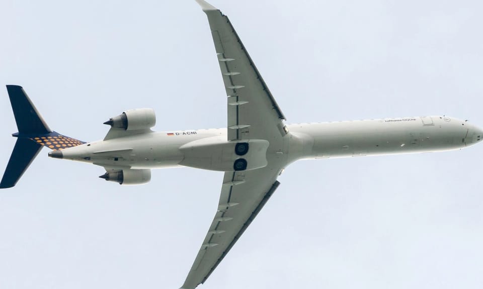 Photo of a Lufthansa CityLine CRJ900 from directly below, the trailing edge of the wing almost straight near the fuselage and swept further out